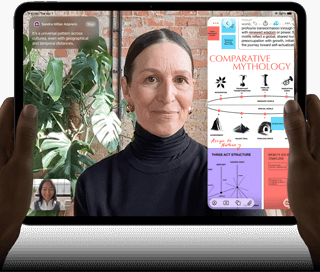 Asztrofekete iPad Pro szemből, fekvő tájolásban, lekerekített sarkokkal, fekete kijelzőkerettel. A bal és jobb szélén
egy-egy kéz fogja, a kijelzőn élőben fordított FaceTime-beszélgetés, valamint egy oktatási célú alkalmazás jelenik meg, amely
egy komparatív mitológiáról szóló prezentációt tartalmaz szöveggel, ábrákkal és kézzel írt jegyzetekkel